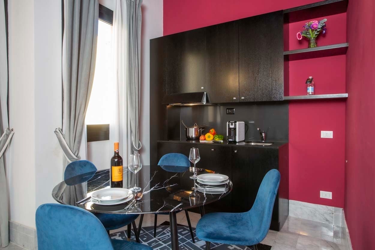 Elegantes Esszimmer mit blaue Stühlen und Kaffee-Ecke im Casual Rinascimento Firenze Hotel.