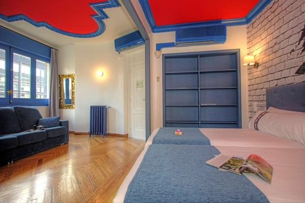 een slaapkamer met twee bedden en een blauwe radiator