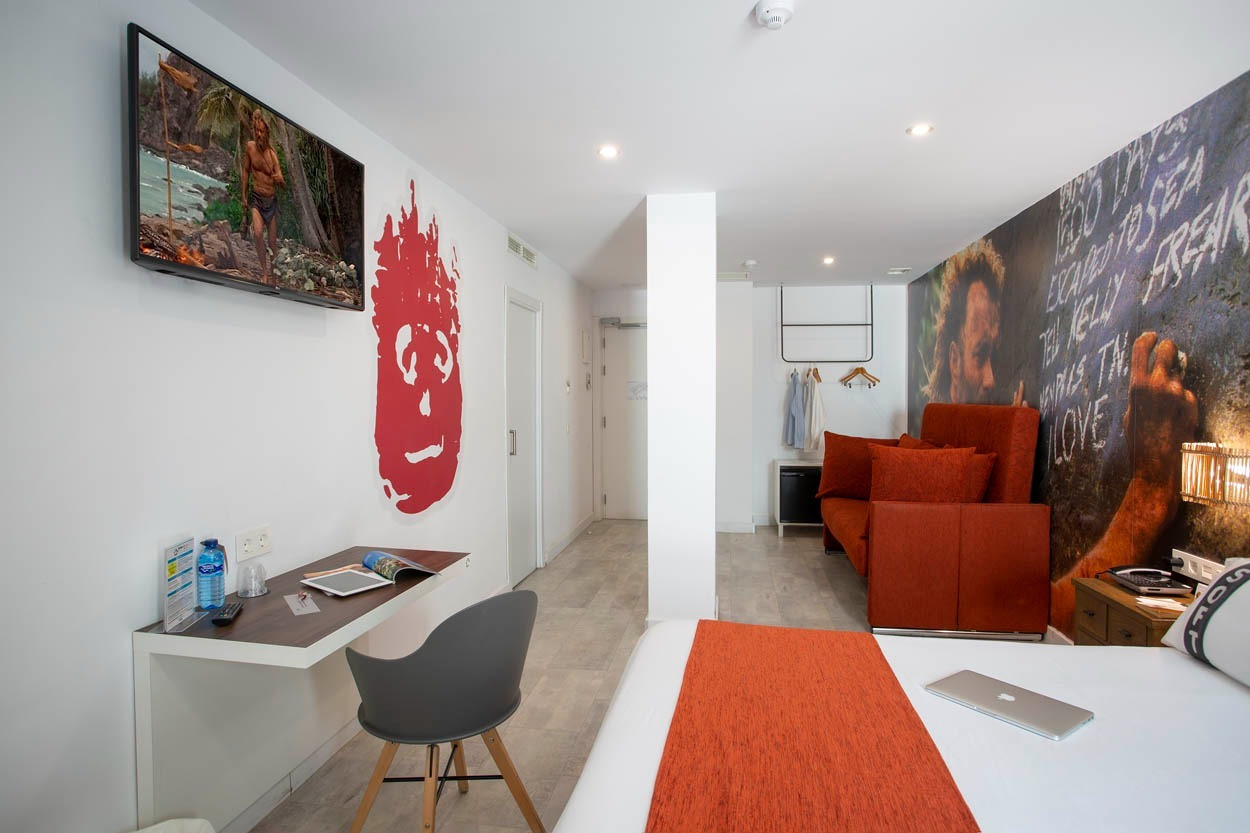 Zimmer im Casual del Mar Málaga: modernes Design mit Fernseher, Schreibtisch und roter Deko. Zentral gelegen.