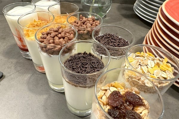 een tafel gevuld met glazen gevuld met yoghurt en granen