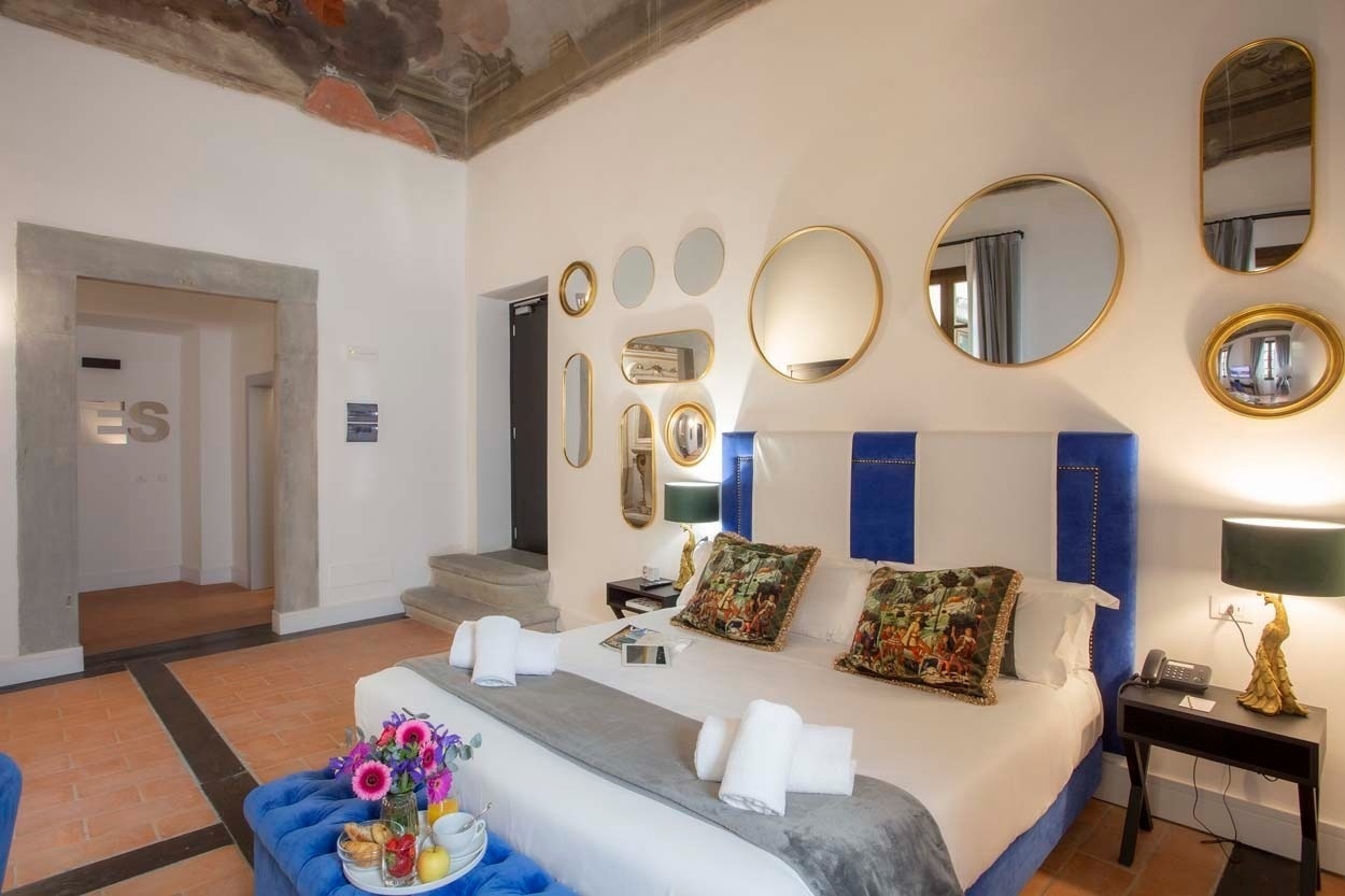 Luxuriöses Schlafzimmer im Casual Rinascimento Firenze mit bequemen Betten, Kunst und Spiegeln.