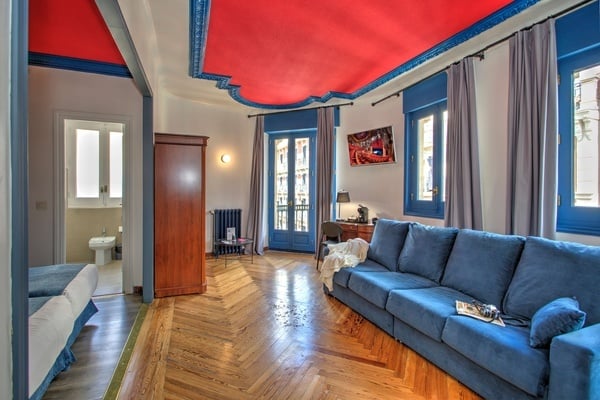 een woonkamer met een blauwe bank en een rode plafond