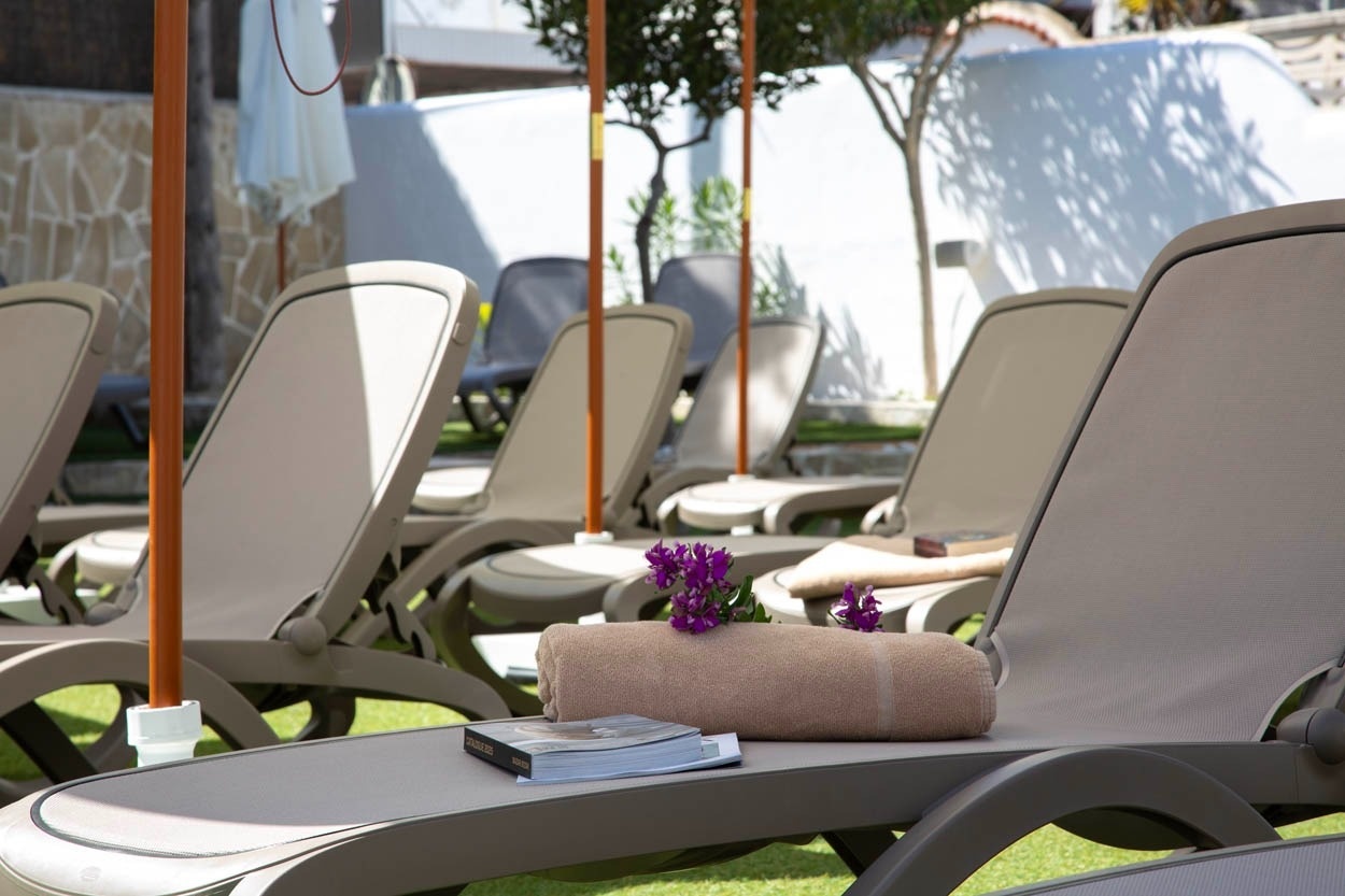 Chaises longues confortables à Casual Bahía Ibiza - Hôtel près de la plage.