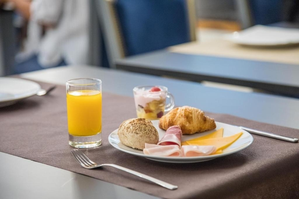 a plate of food and a glass of orange juice on a table
