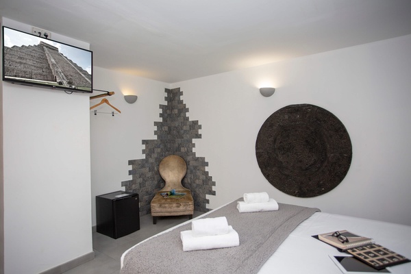 una habitación con una cama y una televisión que muestra una pirámide