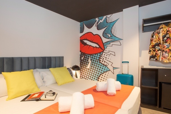 una habitación de hotel con una cama y una maleta