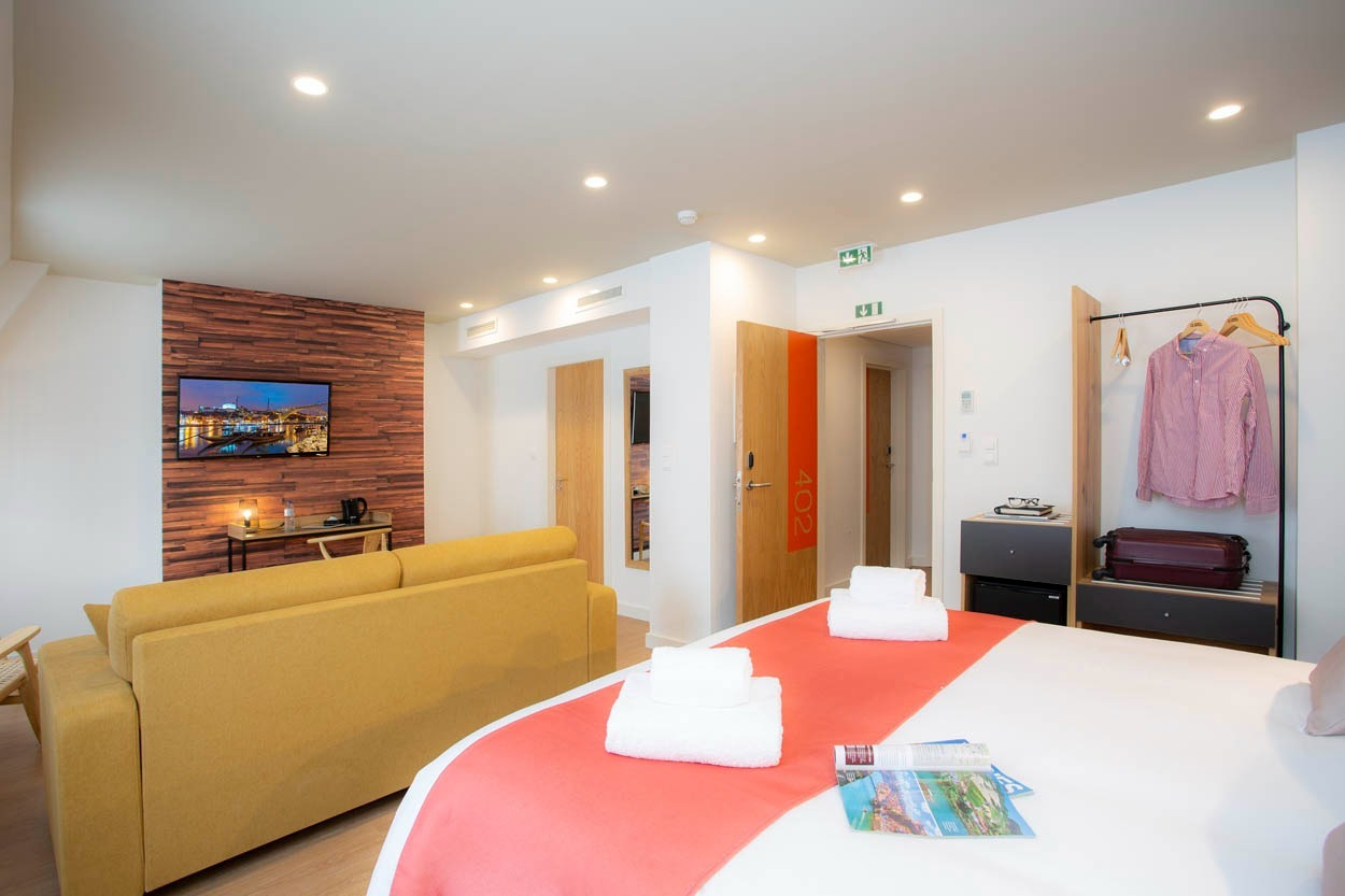 Camera moderna e accogliente, Casual Raízes Porto - Boutique hotel, con divano, TV e letto comodo.