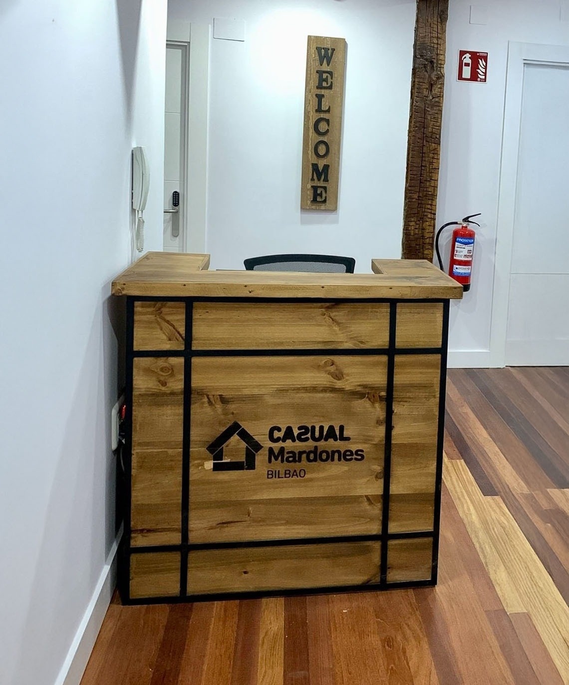 Casual Mardones Bilbao - Rezeption mit Willkommensschild und Feuerlöscher im Casual Hotel Bilbao.