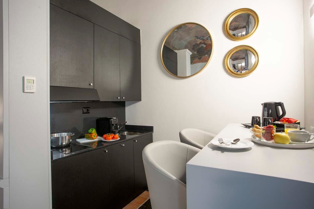 Modernes Hotelzimmer mit Küchenzeile und Frühstückstablett, Casual Rinascimento Firenze – Zentrales Hotel mit Pool in Florenz.