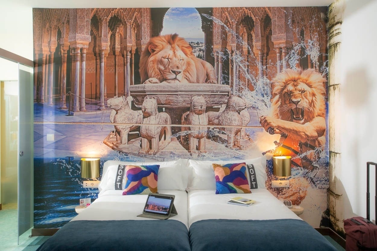 Habitación con mural de leones en Casual Ilbira Granada, hotel boutique centro histórico.