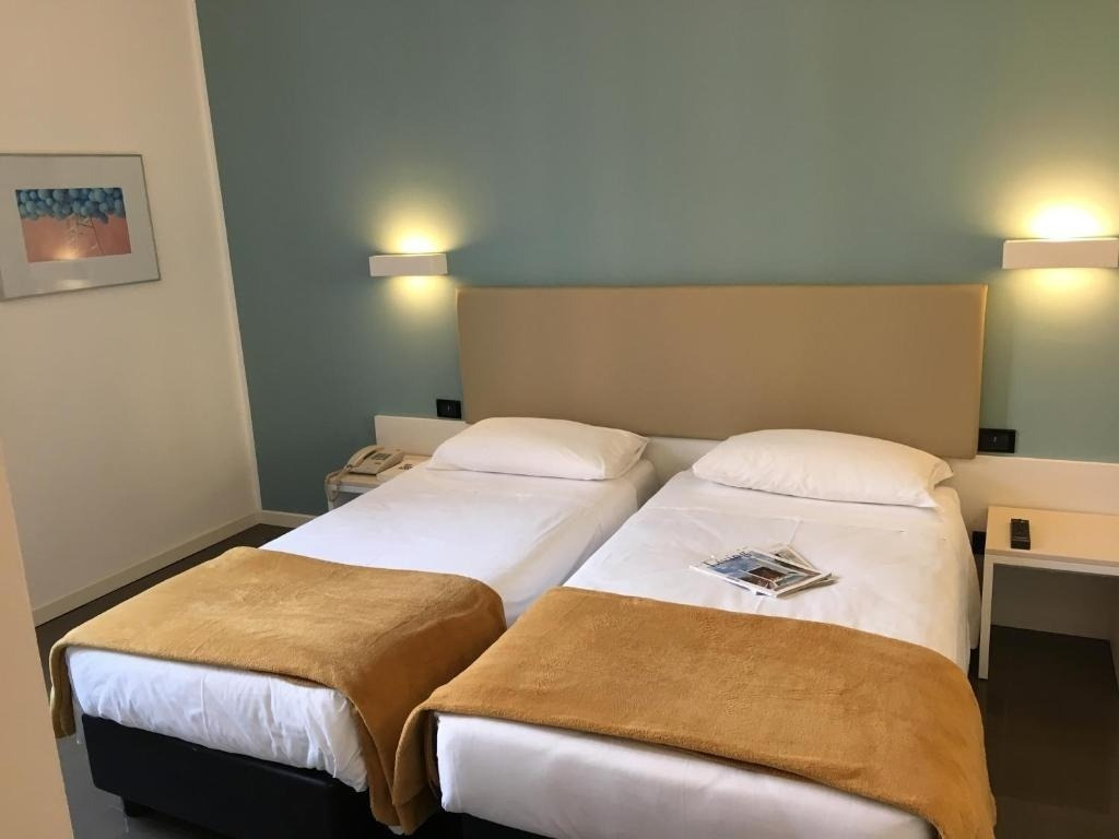 a hotel room with two beds and a picture on the wall