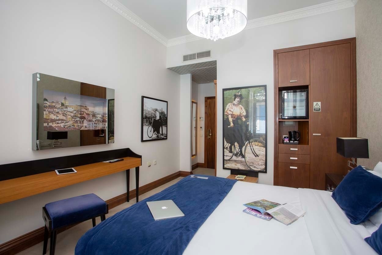 Elegantes Zimmer im Casual Belle Époque - Boutique-Hotel Lissabon: Bett, Schreibtisch & Bilder.