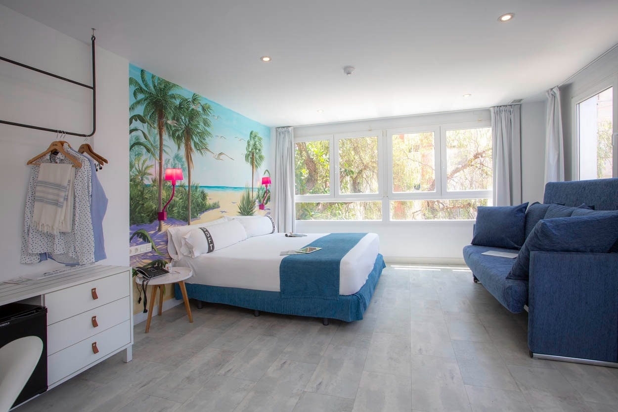 Modernes Hotelzimmer mit Palmen-Wandbild und Meerblick im Casual del Mar Málaga.