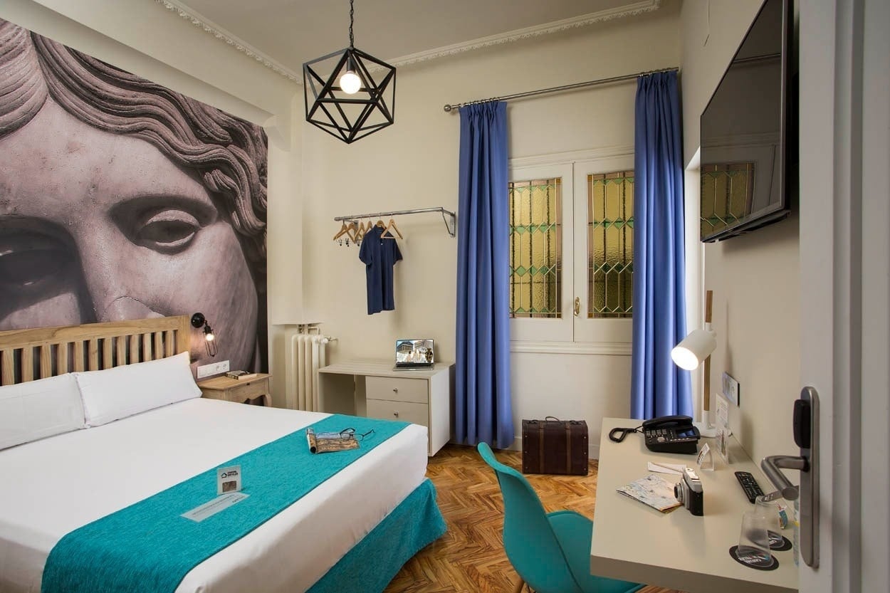 Elegantes Hotelzimmer im Casual del Teatro Madrid mit moderner Kunst, Blauem Akzent & Schreibtisch