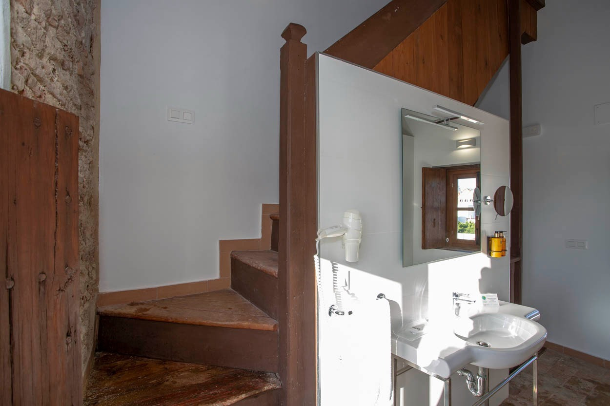 Badezimmer mit Waschbecken, Spiegel und Haartrockner, neben der Treppe im Casual con Duende Cádiz.