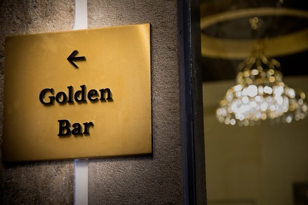 una señal dorada que muestra la dirección hacia el bar dorado