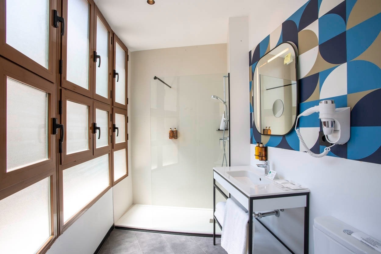 Baño moderno con ducha y lavabo en Casual Vintage Valencia. ¡Reserva ya!