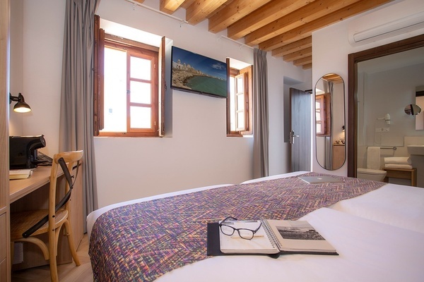 a hotel room with a bed a desk and a mirror