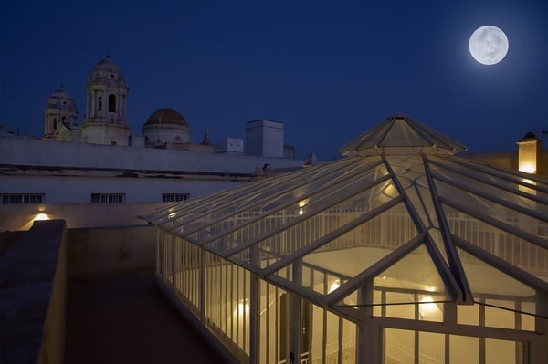 a full moon is visible over a glass building