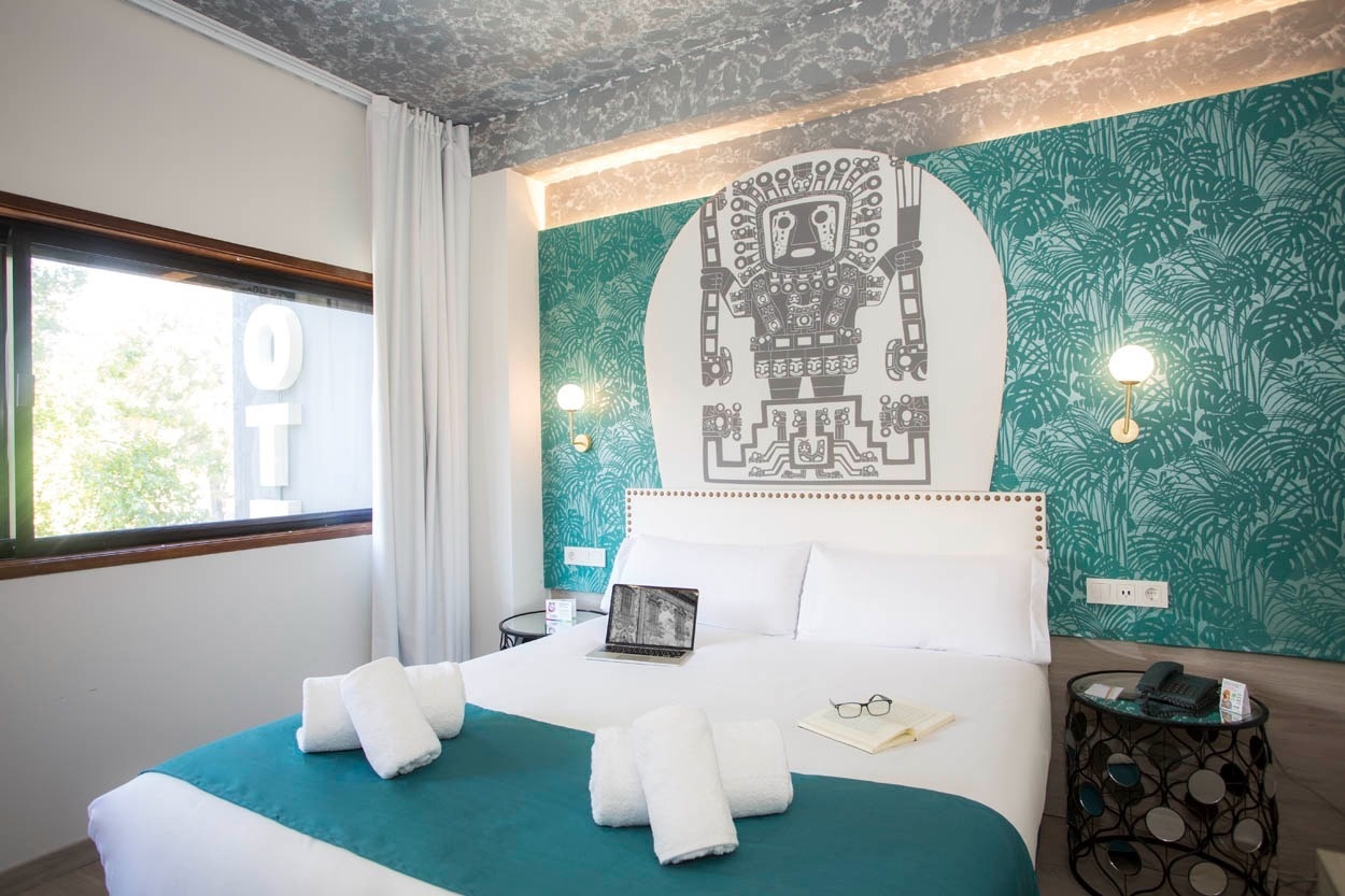 Modernes Doppelzimmer im Casual Inca Porto - Zentrales Hotel in Porto | Casual Hoteles mit Dschungel-Tapete und antiker Wandkunst.