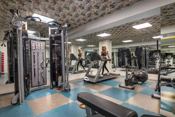 een vrouw loopt op een loopband in een sportschool