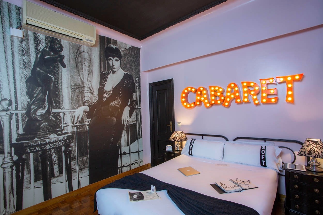 Gemütliches Zimmer im Casual del Teatro Madrid mit „Cabaret“-Leuchtreklame und Kunstwerk.