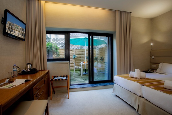a hotel room with two beds and a sliding glass door