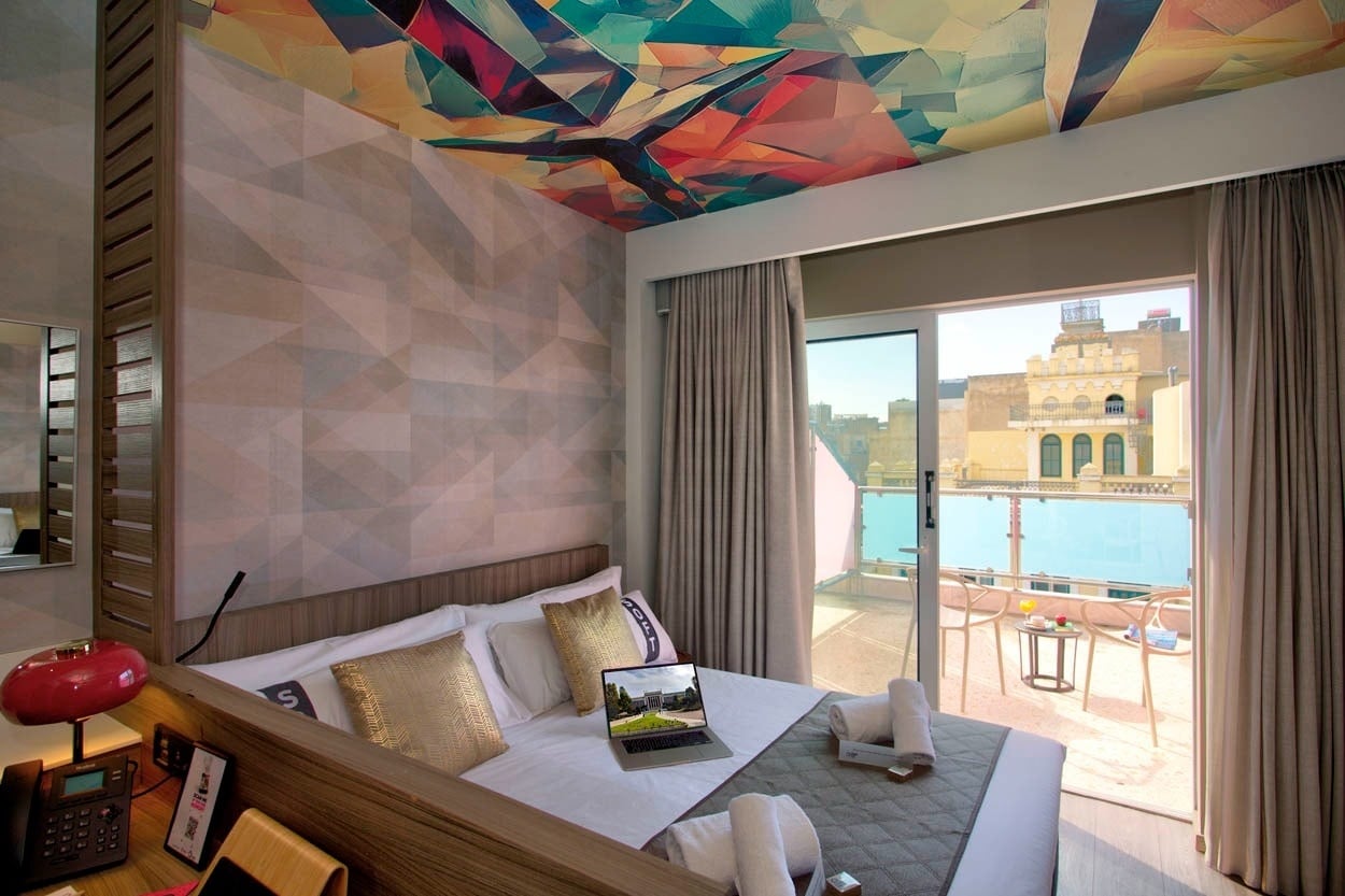 Gemütliches Zimmer im Casual Kubic Athens mit Balkon und Blick auf die Stadt.