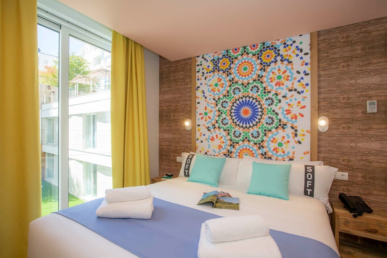 Casual Raízes Porto: camera accogliente con letto king size, decorazione murale colorata e vista giardino.