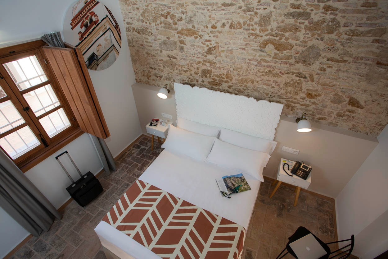 Gemütliches Zimmer im Casual con Duende Cádiz: Historisches Zentrum, Holzbalken, Steinwände, Doppelbett.