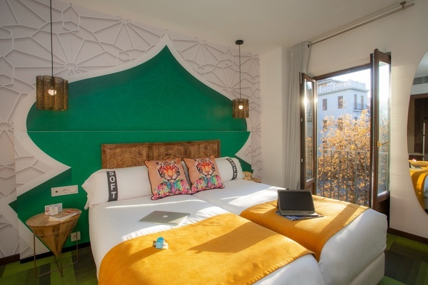 um quarto de hotel com duas camas e um laptop em cima da cama