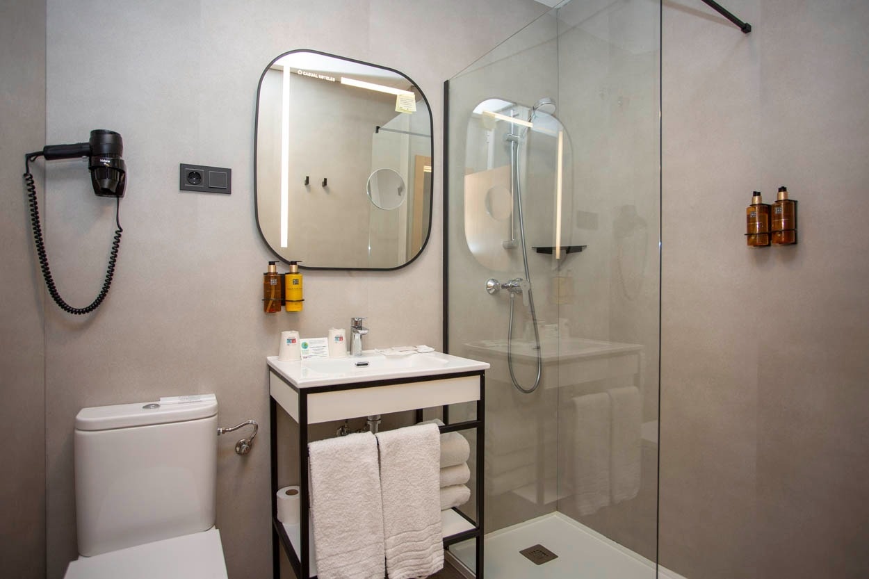 Modernes Badezimmer im Casual del Cine Valencia: Dusche, Waschbecken, Toilette & Föhn.