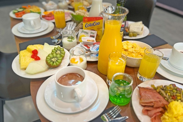 una mesa llena de platos de comida y una bolsa de cola cao