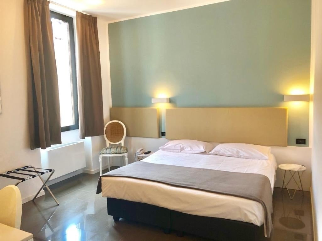 a hotel room with a bed and a chair