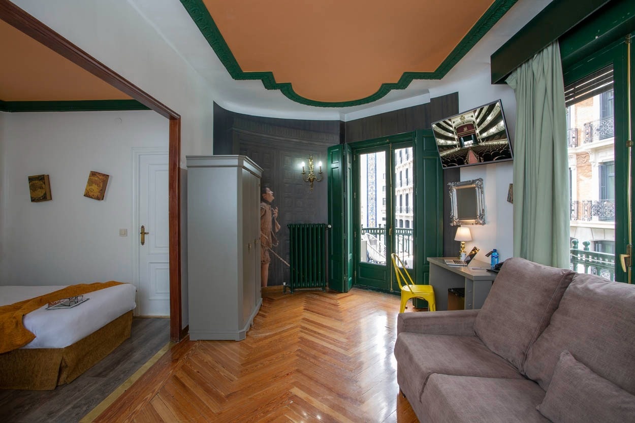 Gemütliches Zimmer im Casual del Teatro Madrid – Boutique-Hotel nahe der Gran Vía, mit zwei Betten, Schreibtisch und Sofa.