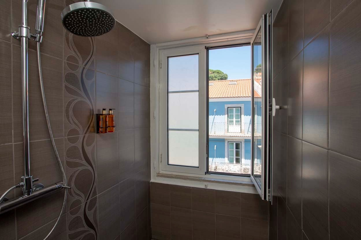Modernes Duschbad im Casual Belle Époque Hotel mit Blick auf Lissabons Altbau. Idealer Aufenthalt im Zentrum.