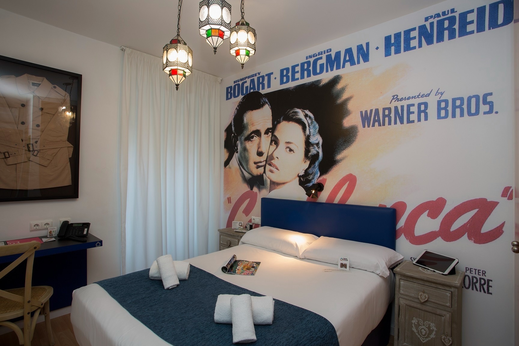 una habitación con una cama y un cartel de bogard bergman henreid
