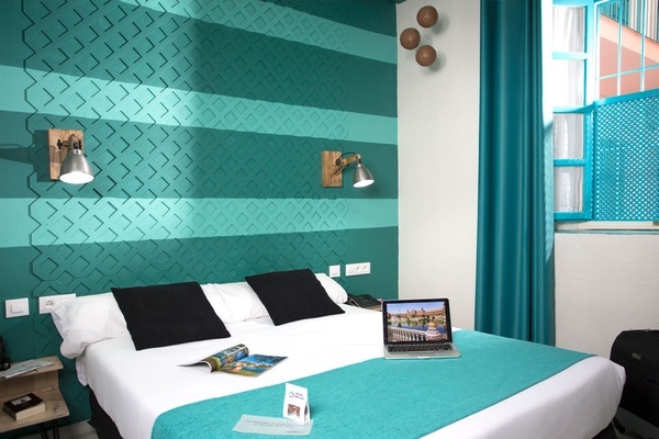 a hotel room with a bed and a laptop on it