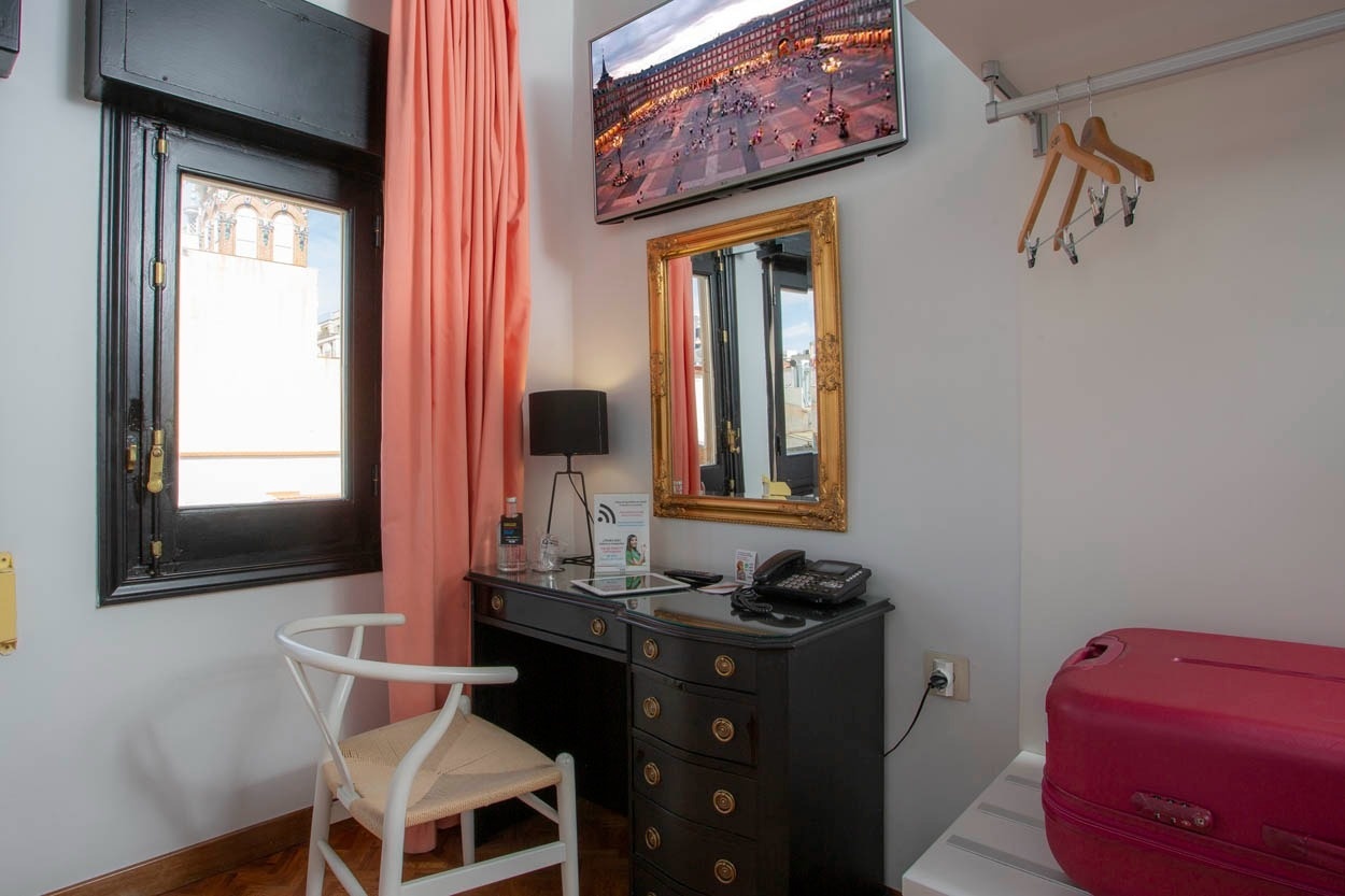 Gemütliches Zimmer im Casual del Teatro Madrid mit Schreibtisch, Spiegel und Blick auf die Gran Vía.