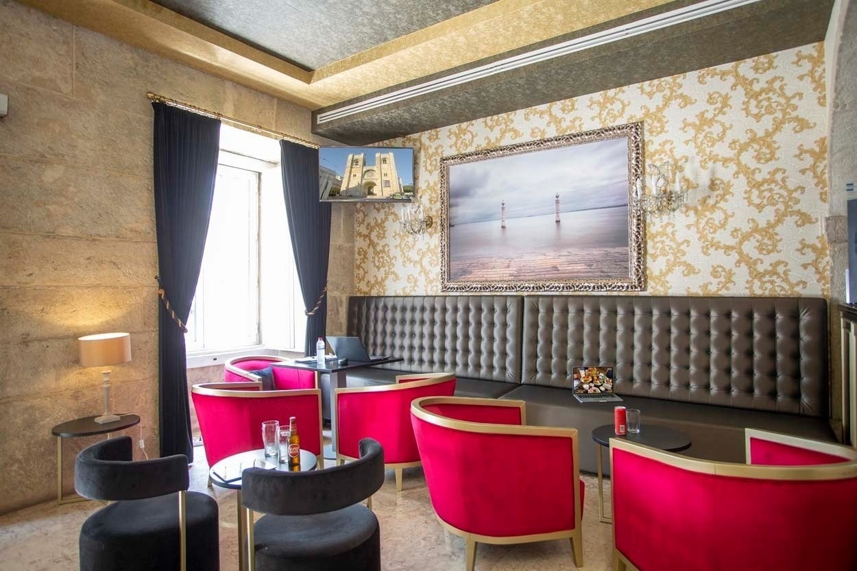 Gepolsterte Sitzbank mit Laptop und Getränken im Casual Belle Époque - Boutique-Hotel im Zentrum von Lissabon | Casual Hoteles