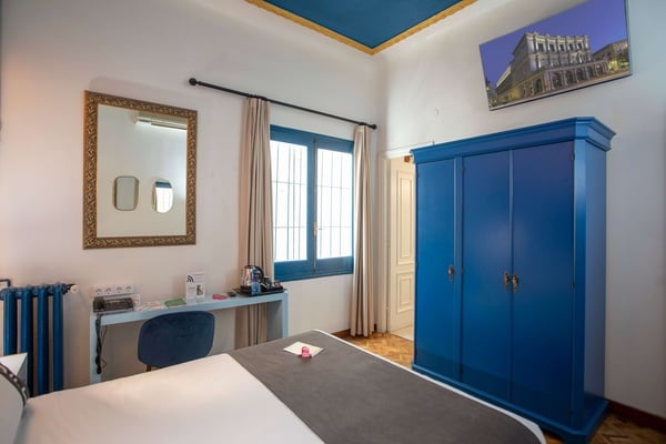een slaapkamer met een bed en een blauwe kast