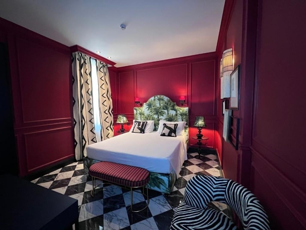 a bedroom with red walls and a zebra print chair