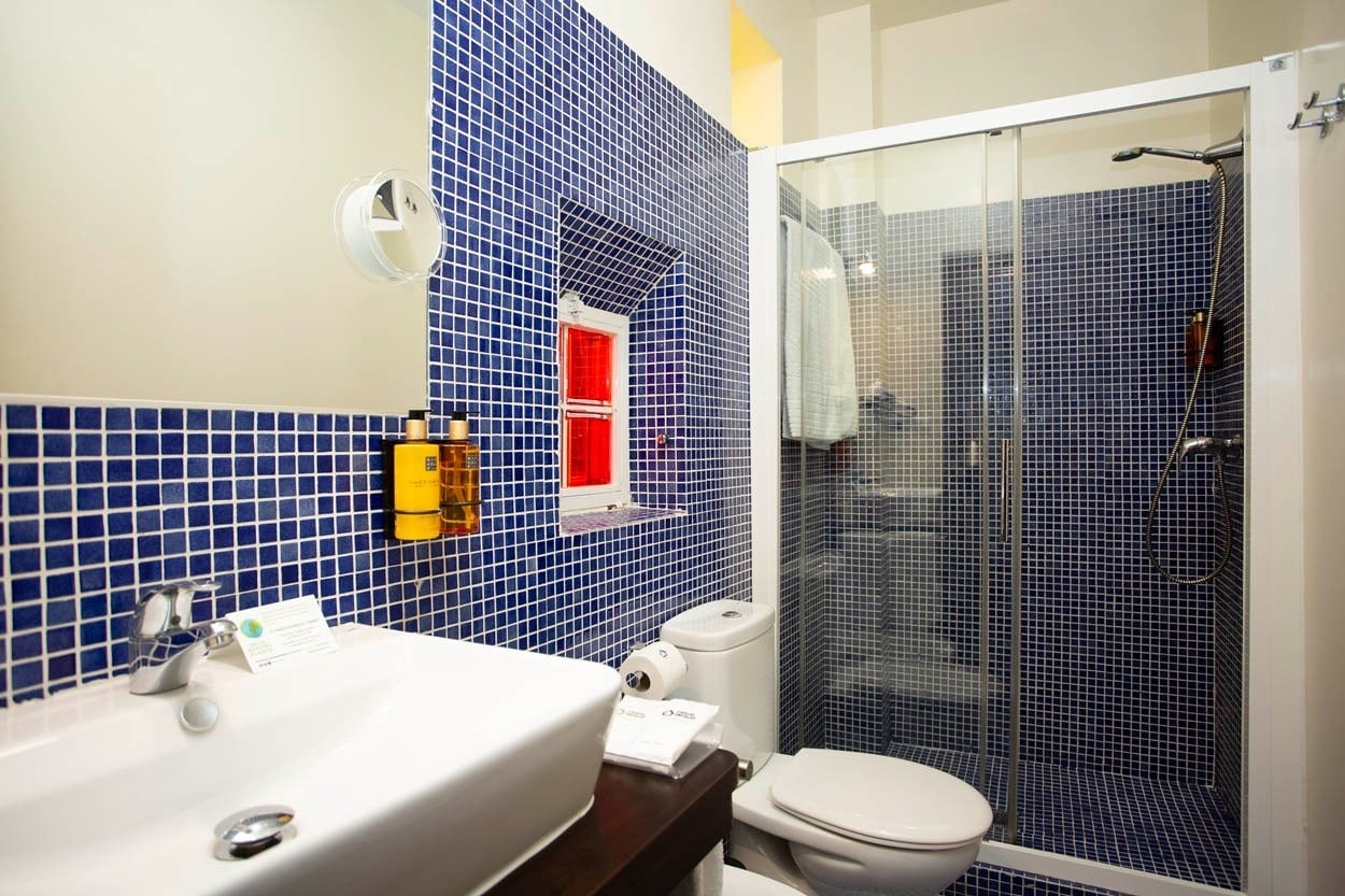 Baño moderno con azulejos azules en Casual Ilbira Granada. Hotel boutique en el centro histórico.
