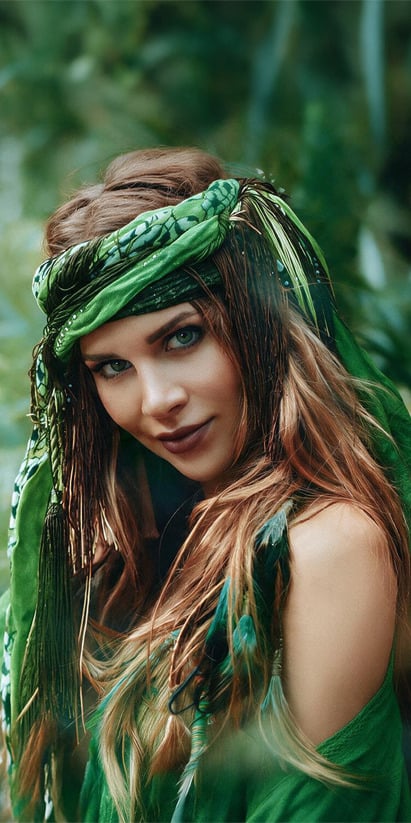 Bohemian-style woman with green headscarf and feathers, perfect for a unique Casual: Corporativa experience.