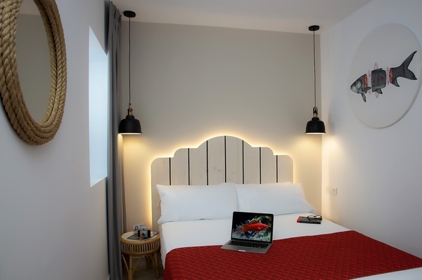 a small bedroom with a laptop on the bed