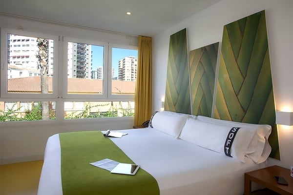 una habitación de hotel con una cama king size y una almohada con la palabra sofy impresa en ella