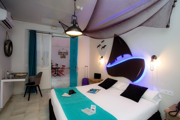 a hotel room with a bed that has a sailboat headboard