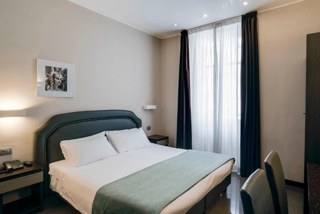 a hotel room with a bed and a picture on the wall