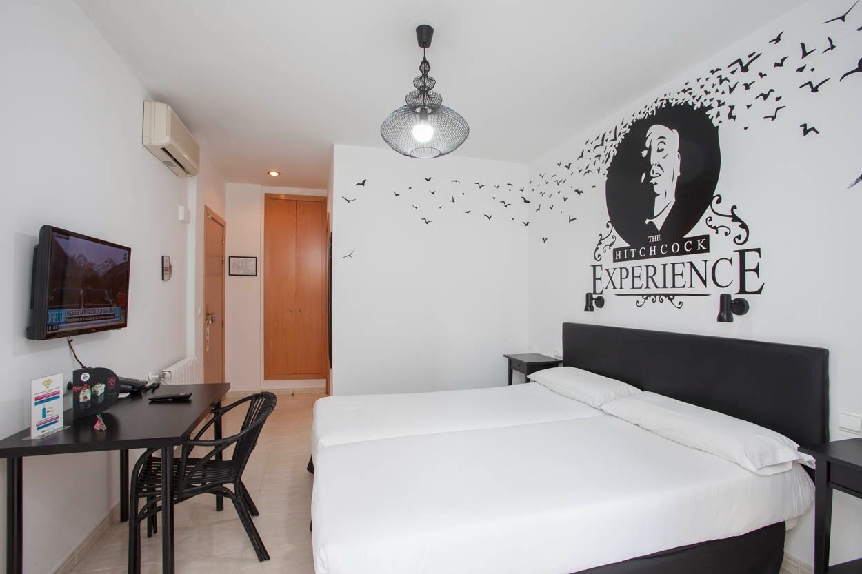 Zwei Einzelbetten im Zimmer des Casual del Cine Valencia – Themenhotel in Valencia mit Hitchcock-Motiv.