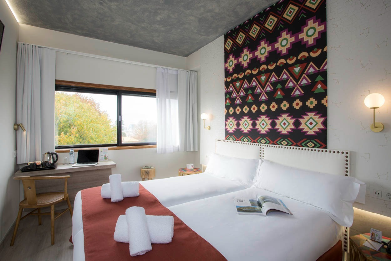 Modernes Zimmer im Casual Inca Porto Hotel mit zwei Betten und schöner Aussicht.